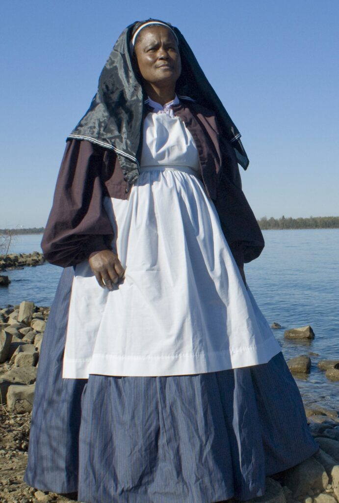 Marlene Rivero dressed as Ann Bradford Stokes by the river