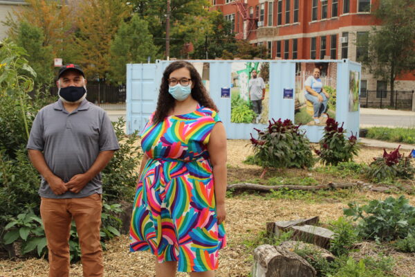 man and woman with masks standing in a lot in front of a decorated trailer