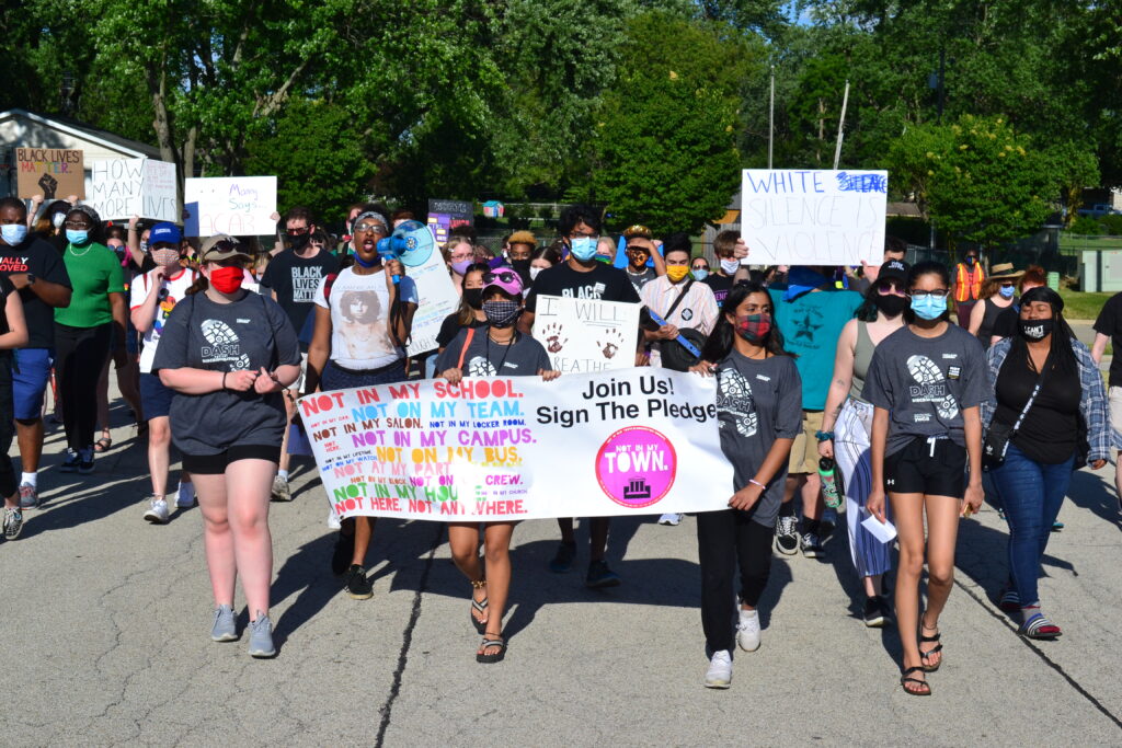 youth walking down the street with protest signs