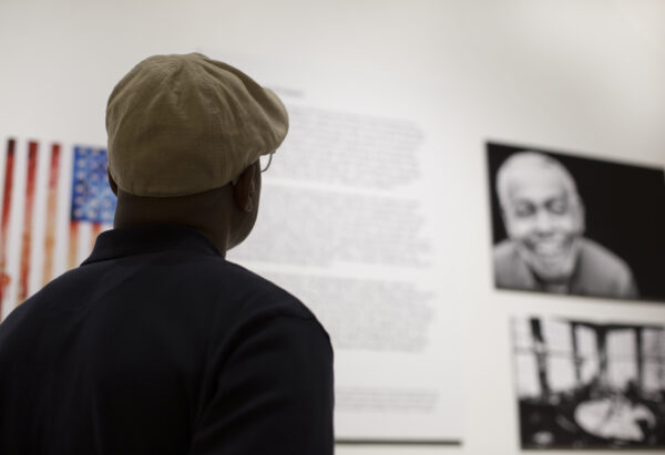 Male with hat walking through the Of Poetry and Protest Exhibition at the Guild Literary Complex